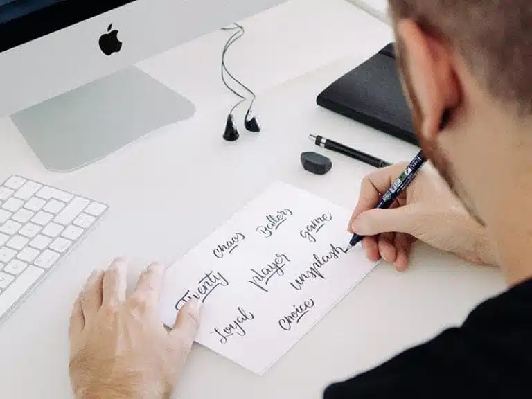 Čovjek snimljen odozada nešto piskara na stolu